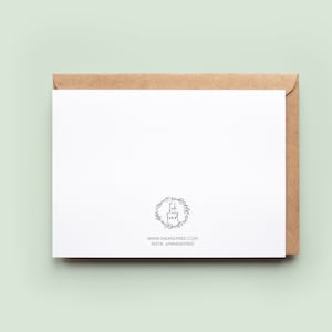 Peut inclure: Une carte de v&oelig;ux blanche vierge avec une enveloppe marron. La carte pr&eacute;sente un motif floral circulaire avec le texte "Ink and Fred". Le site web et le compte Instagram sont imprim&eacute;s en dessous.