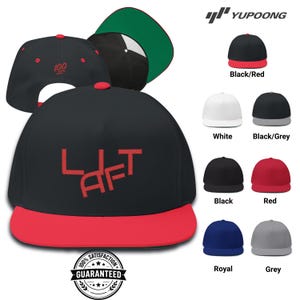 May include: Black baseball cap with a red brim and the embroidered word "LAFT" in red. Additional caps in black, white, red, grey, and blue are displayed. The image also shows a cap with the number "100" embroidered in red.