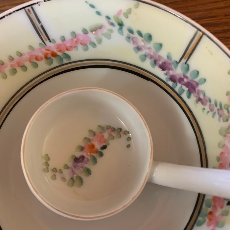 May include: A white porcelain bowl with a floral design in shades of pink, purple, and green. The bowl has a smaller, matching bowl inside with a similar floral design.