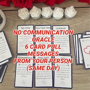 May include: An oracle card set with six cards featuring messages about relationships. The cards are black with white text and heart illustrations. The image includes white rose-shaped candles and red roses.
