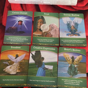 Puede incluir: Seis cartas de or&aacute;culo con bordes verdes y detalles dorados. Las cartas muestran im&aacute;genes de &aacute;ngeles, faros y otras im&aacute;genes simb&oacute;licas. Los t&iacute;tulos de las cartas son: Cambio de carrera, Confianza, Sanaci&oacute;n energ&eacute;tica, Libertad, Expresi&oacute;n creativa y Deseos del coraz&oacute;n.