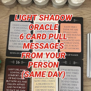 May include: A tarot card reading with six cards laid out, featuring the text "Light Shadow Oracle 6 Card Pull Messages From Your Person (Same Day)". The cards have various messages and are surrounded by white candles.