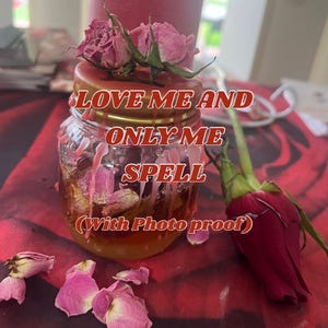 Puede incluir: Un frasco de vidrio con tapa dorada lleno de pétalos de rosa y líquido. El frasco tiene el texto "LOVE ME AND ONLY ME SPELL (With Photo proof)". Hay rosas secas y pétalos de rosa en la mesa.