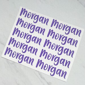 Może przedstawiać: Osiem fioletowych naklejek winylowych z napisem "Morgan" napisanym kursywą.
