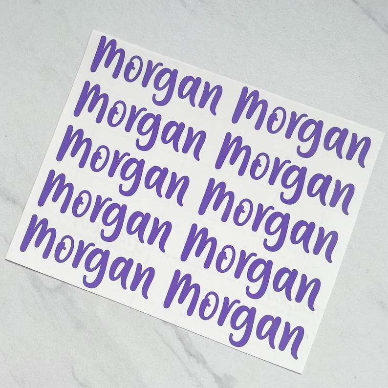 Może przedstawiać: Osiem fioletowych naklejek winylowych z napisem "Morgan" napisanym kursywą.