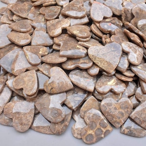 Peut inclure: Un ensemble de pierres en forme de cœur dans des tons bruns et beiges. Les pierres ont une surface texturée avec un aspect naturel et organique. Les cœurs varient en taille et sont dispersés.