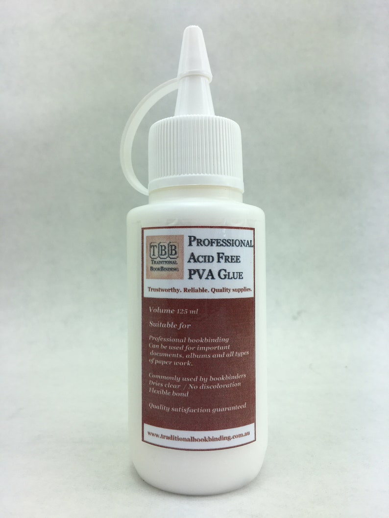 K&ouml;nnte beinhalten: Eine wei&szlig;e Flasche s&auml;urefreier PVA-Kleber f&uuml;r die Buchbinderei. Die Flasche ist mit "Professional Acid Free PVA Glue" und "Trustworthy. Reliable. Quality supplies." beschriftet. Die Flasche hat ein Fassungsverm&ouml;gen von 125 ml und eignet sich f&uuml;r professionelle Buchbinderei, Dokumente, Alben und alle Arten von Papierarbeiten. Sie trocknet klar, verf&auml;rbt sich nicht und bietet eine flexible Bindung. Das Etikett enth&auml;lt auch die Website www.traditionalbookbinding.com.au.