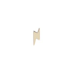 Peut inclure: Boucle d'oreille dorée en forme d'éclair. La boucle d'oreille a une surface lisse et polie et un design minimaliste. L'éclair est un symbole populaire, souvent associé à l'énergie et à la puissance. Cet accessoire est élégant.