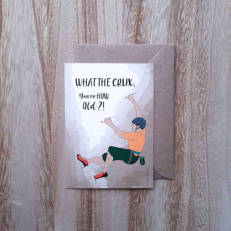May include: A greeting card with a humorous illustration of a rock climber and the text "What the crux, you're how old?!"
