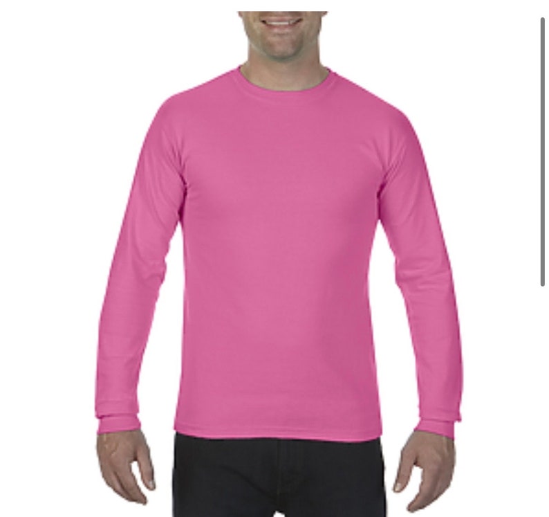 May include: A long-sleeved shirt in a bright pink color. The shirt has a crew neck and is made of a soft, comfortable fabric.