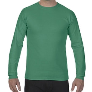 May include: A long-sleeved t-shirt in a solid green color. The shirt has a crew neck and a relaxed fit.