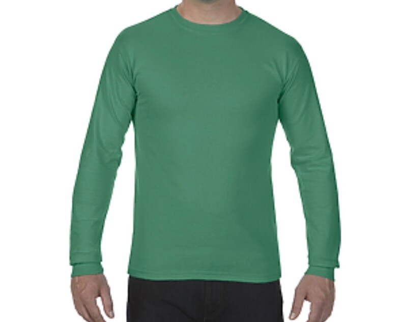 May include: A long-sleeved t-shirt in a solid green color. The shirt has a crew neck and a relaxed fit.