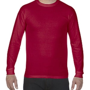 May include: A long-sleeved t-shirt in a deep red color. The shirt has a crew neck and a relaxed fit.