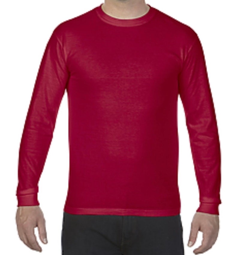 May include: A long-sleeved t-shirt in a deep red color. The shirt has a crew neck and a relaxed fit.