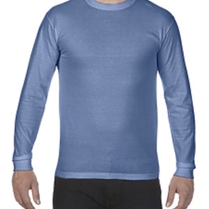 May include: A long-sleeved shirt in a light blue color. The shirt has a crew neck and a relaxed fit.