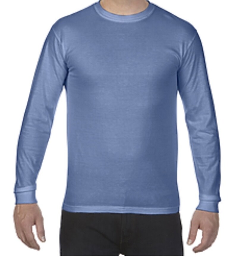 May include: A long-sleeved shirt in a light blue color. The shirt has a crew neck and a relaxed fit.