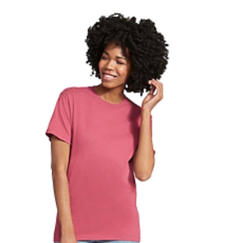 May include: A short-sleeved, crew neck t-shirt in a dusty rose color. The shirt is made of a soft material and has a classic, casual style. The t-shirt is a solid color and is suitable for everyday wear.