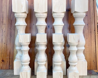 May include: Set of six unfinished wooden table legs with a turned design. The legs are different heights and are arranged in a row on a wooden surface.