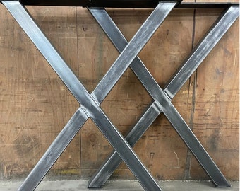May include: Two black metal table legs with an X-shaped design. The legs are made of thick, sturdy metal and have a rustic, industrial look.