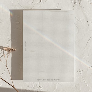 May include: A white gridded notepad with the text "BIG PLANS. GOOD IDEAS. HIGH STANDARDS." printed at the bottom.