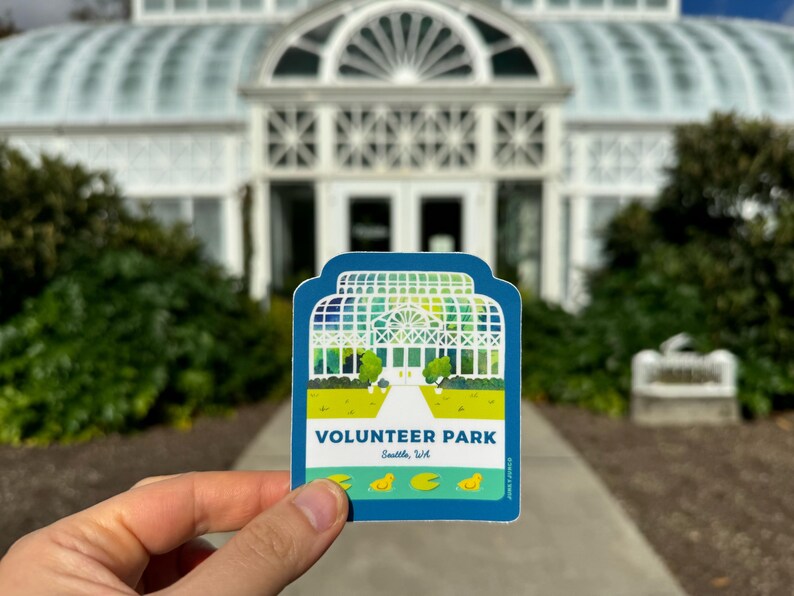 May include: A blue and green sticker with a white illustration of a greenhouse and the text "VOLUNTEER PARK Seattle, WA".