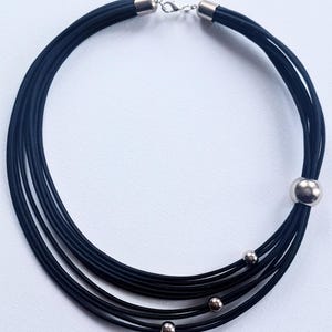 Zwarte koordslabketting: dikke textielsieraden, zilveren kralen