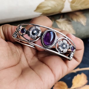 Può includere: Braccialetto in argento con una pietra preziosa ametista e dettagli floreali.