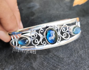 Puede incluir: Pulsera de plata con un delicado diseño de filigrana y tres piedras ovaladas de labradorita azul.