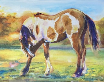 May include: An oil painting of a horse in a field. The horse has a brown and white coat, with a blue tail and mane. The horse is bending down, as if grazing. The background is a blurred landscape with yellow and orange hues.