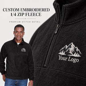 May include: A black quarter-zip fleece pullover featuring a stand-up collar and a white embroidered mountain graphic with the text Your Logo. The text CUSTOM EMBROIDERED 1/4 ZIP FLEECE PREMIUM STITCH DETAIL is visible in the upper left corner.
