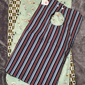 May include: Three baby bibs in different patterns. One bib has vertical red, white, and blue stripes. The other two bibs have a light green background with a pattern of animals. The bottom bib has a chess board pattern.