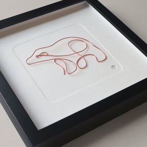 Könnte beinhalten: Eine gerahmte Skulptur eines Eisbären aus Kupferdraht vor weißem Hintergrund. Die Skulptur ist schlicht und elegant mit einem minimalistischen Design.