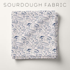May include: Fabric with a repeating pattern of bread-making illustrations in navy blue on a cream background. The design includes loaves of bread, bowls, spoons, jars, and the words "FLOUR", "SUGAR", and "BUTTER". The text "SOURDOUGH FABRIC" is at the top.