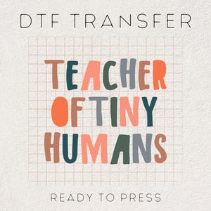May include: A colorful iron-on transfer design that says "Teacher of Tiny Humans" on a white grid background. The text is in a playful, hand-drawn style. The design is ready to press.
