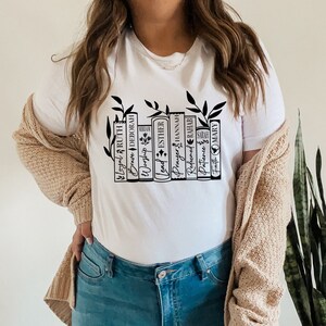 May include: White t-shirt with a black graphic of a bookshelf with books that have names of women from the Bible. The books are "Loyal Ruth", "Brave Deborah", "Worship Miriam", "Lead Esther", "Prayer Hannah", "Refined Rahab", "Patience Sarah", and "Faith Mary".