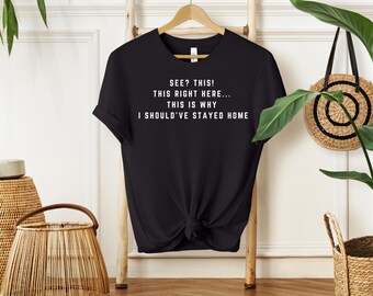 May include: Black t-shirt with white text that reads "SEE? THIS! THIS RIGHT HERE... THIS IS WHY I SHOULD'VE STAYED HOME".