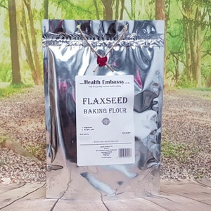 May include: A silver resealable pouch with a white label that reads "Health Embassy" and "Flaxseed Baking Flour". The pouch is sealed with a red wax seal.