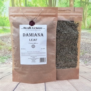 Puede incluir: Una bolsa de papel marrón con una ventana transparente que muestra hojas de Damiana secas en su interior. La bolsa tiene una etiqueta que dice "Damiana Leaf (Turnera diffusa)" e incluye información sobre el producto y la empresa, Health Embassy LTD.