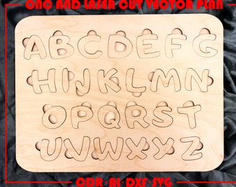 May include: Wooden alphabet puzzle featuring letters A to Z cut out in a rounded font. The letters are arranged in three rows on a light brown wooden board.