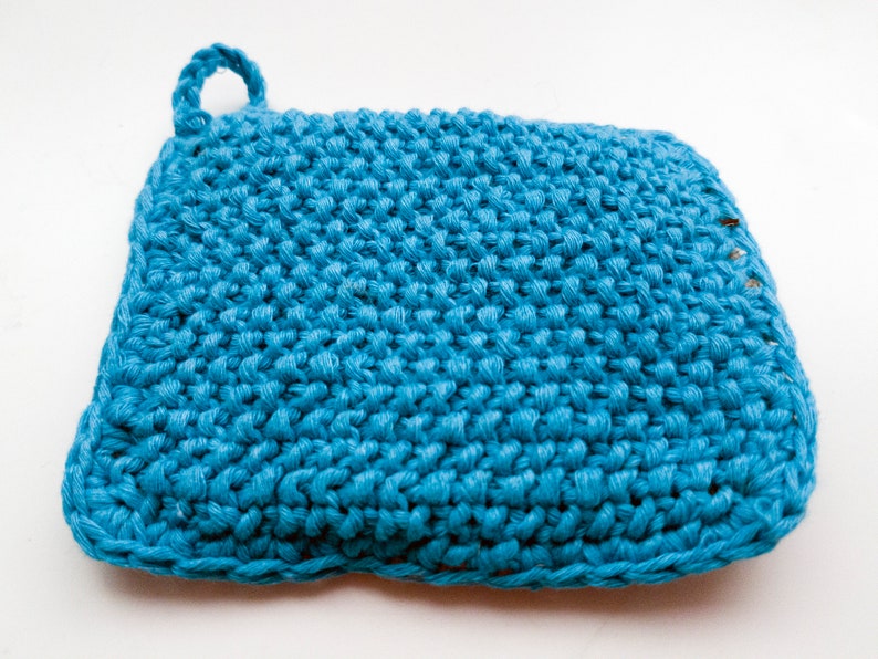 May include: A blue crocheted dishcloth with a loop handle. The dishcloth is made of a textured yarn and has a slightly wavy edge.