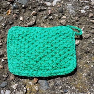 May include: A green crocheted dishcloth or pot holder with a loop for hanging.