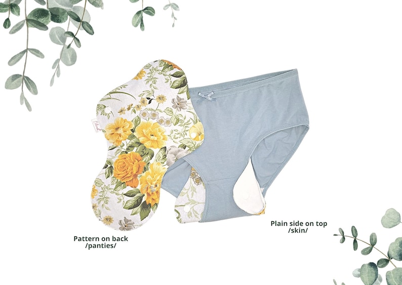 May include: A light blue reusable panty liner with a floral pattern on the back. The liner has a plain side for contact with skin.  The text "Pattern on back /panties/" is written below the liner with a floral pattern. The text "Plain side on top /skin/" is written below the liner with a plain side.