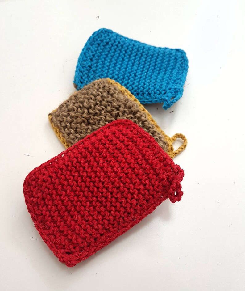May include: Three knitted dishcloths in red, brown and blue. The dishcloths are made from a textured yarn and have a slightly rough surface.