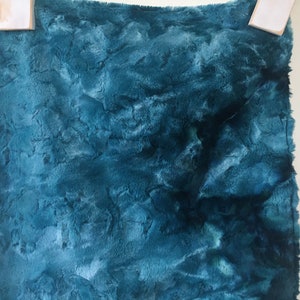 May include: Teal blue faux fur fabric with a soft, fluffy texture.