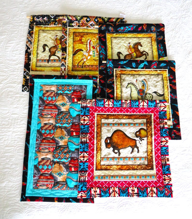 May include: A collection of Native American-themed wall hangings. The artwork features images of Native Americans on horseback, pottery, and a bison. The borders are adorned with colorful patterns and designs in red, turquoise, and black.