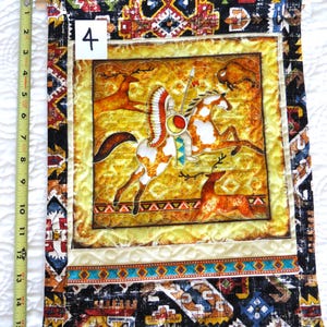 May include: A rectangular wall hanging with a Native American theme. The central image depicts a Native American on horseback with a buffalo and deer. The border features geometric patterns in black, brown, and turquoise. The wall hanging is approximately 16 inches long.