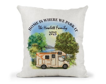 May include: A white throw pillow with the text "Home is where we park it The Howlett Family 2023" and a watercolor illustration of a camper van parked in a grassy area by a lake.