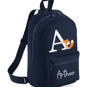 May include: Navy blue backpack featuring a white letter 'A' and a fox illustration. The backpack has a front zipped pocket and the name 'Arthur' in white script. Includes adjustable shoulder straps and a top handle.