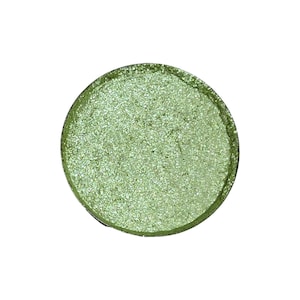 以下が含まれることがあります： キラキラ光る緑色の丸いアイシャドウ