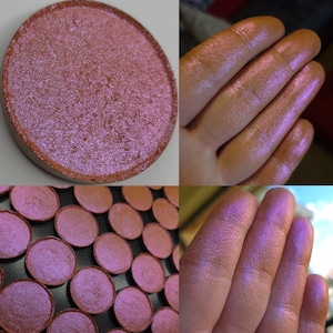 Könnte beinhalten: Nahaufnahme eines pink- und violettfarbenen, schimmernden Lidschattens. Der Lidschatten ist in einer runden Schale, auf einer Hand und in einem Raster mit mehreren Schalen zu sehen. Der Lidschatten hat ein schimmerndes Finish.